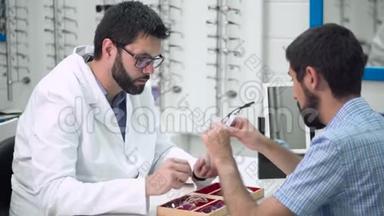 眼科医生正在帮助客户在眼科诊所选择最合适的眼镜。